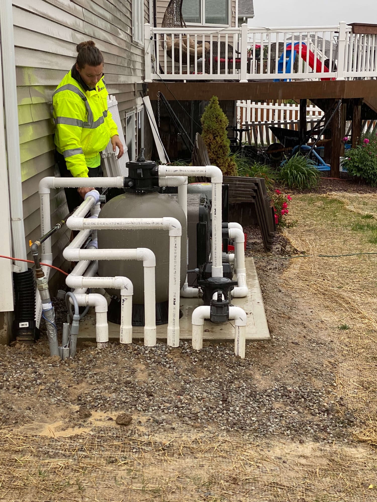 Andrews Plumbing technician installing piping outside a home