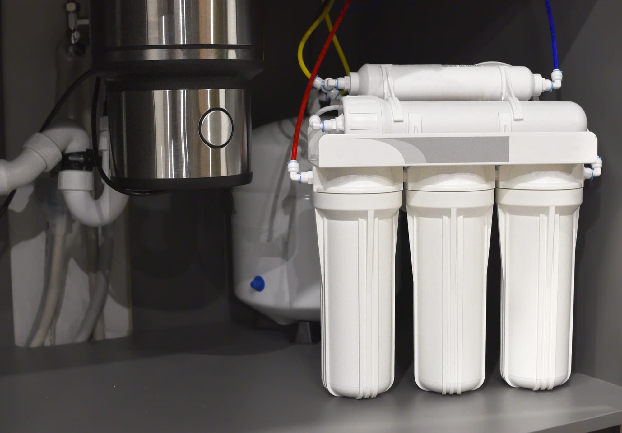 Multi-stage water filtration system installed under a sink